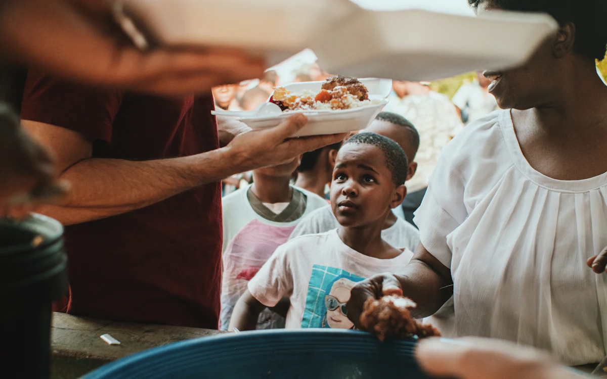 Hot meals being handed out to children at a community food distribution